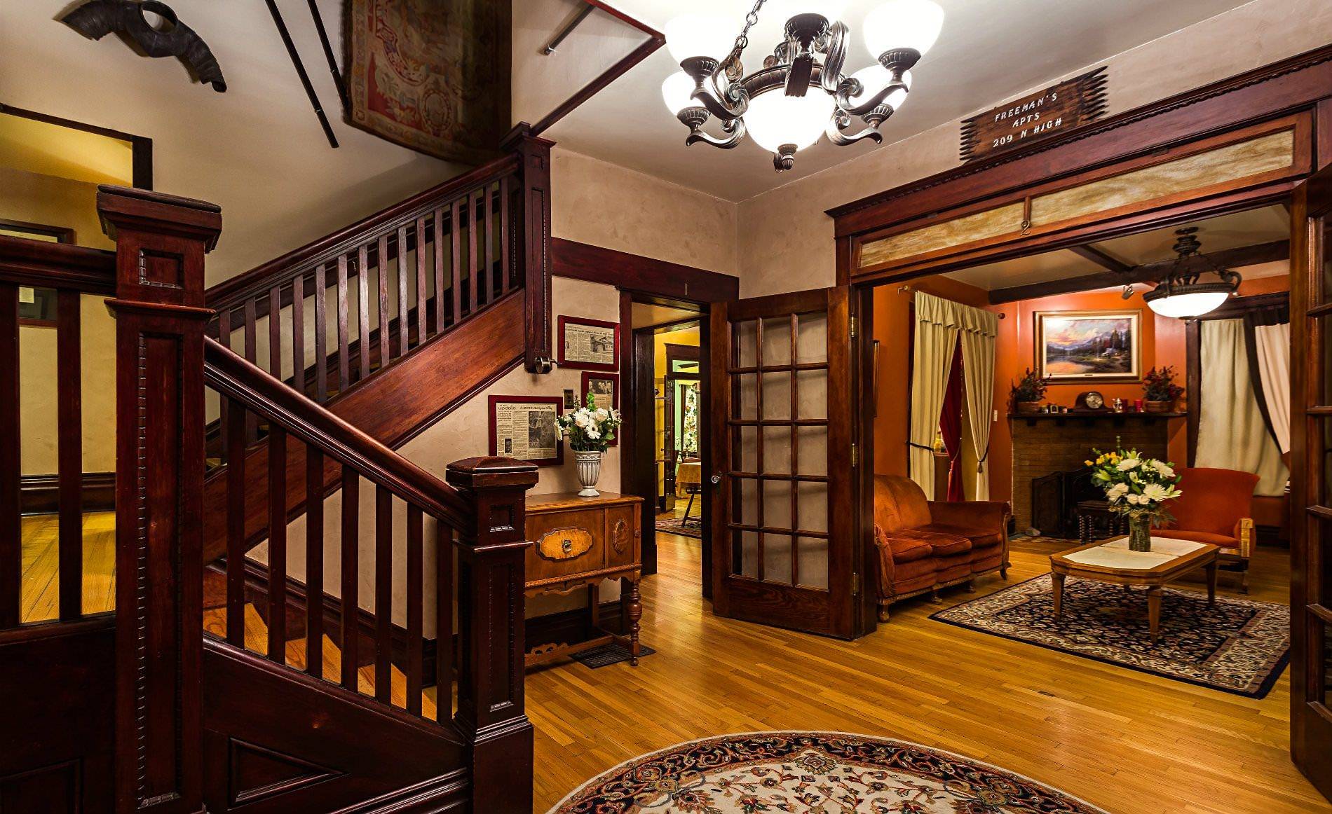 View from bottom of staircase with landing into dining room and common areas. 